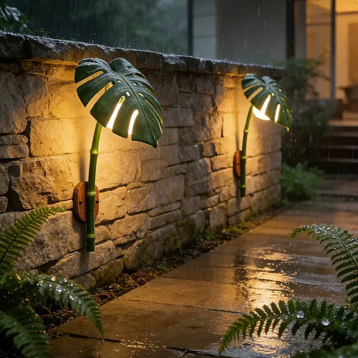 Luminaire extérieur leavah wall lamp en forme de feuille de monstera verte avec tiges en bambou et éclairage chaud