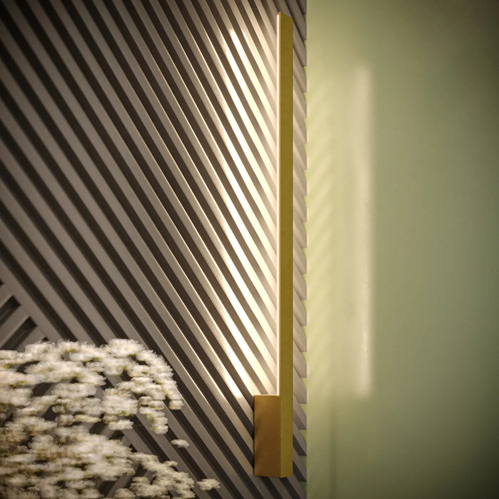 Applique murale lahti m doré avec module led et boîtier étroit diffusant lumière chaude sur fond texturé rayé