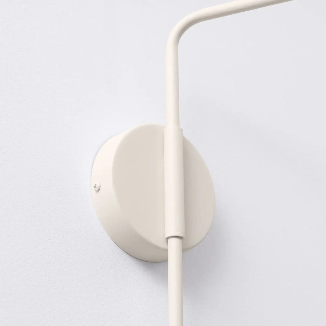 Applique murale moderne beige avec bras simple en métal courbé et abat-jour géométrique circulaire pour intérieur minimaliste