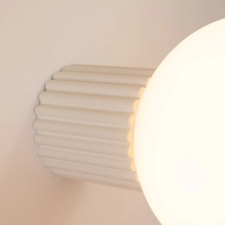 Applique murale lampe halo beige avec base cylindrique côtelée et sphère laiteuse pour bureau décorative