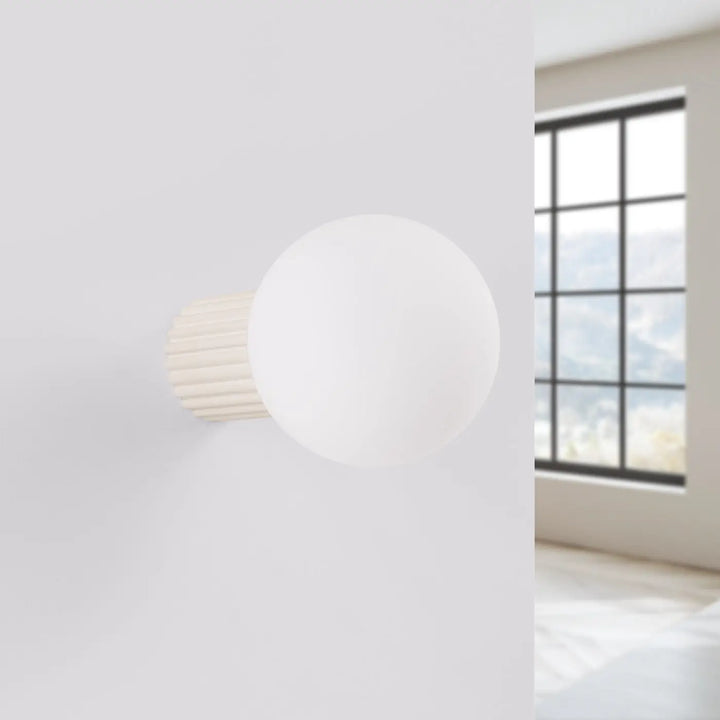 Applique murale halo beige avec sphère laiteuse blanche et base cylindrique côtelée idéale pour bureau décorative
