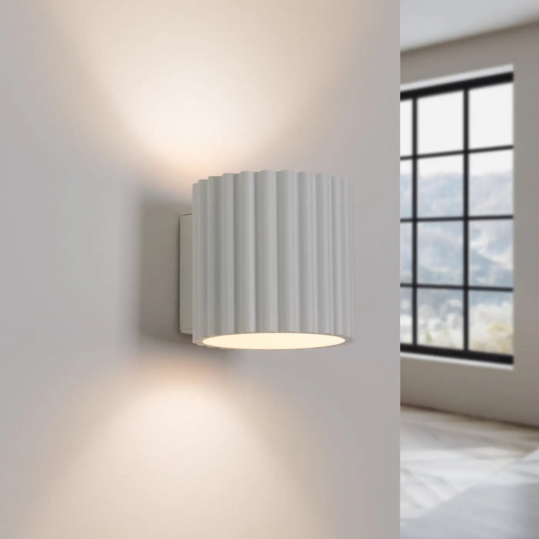 Applique murale aura blanc avec forme unique inspirée, cylindre vertical à rainures diffusant une lumière chaude uniforme