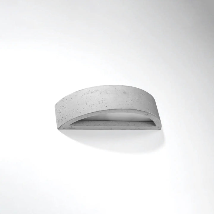 Applique murale atena en béton avec design minimaliste courbé créant une atmosphère harmonieuse pour agencements industriels