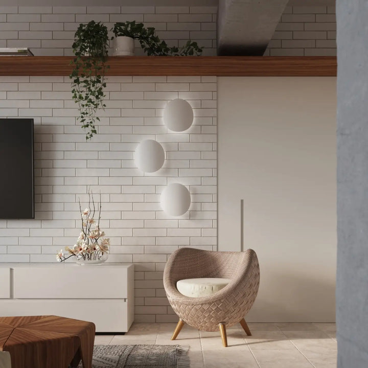 Applique murale senses blanc avec design original fera et luminaire intemporel proche d un fauteuil beige en osier tissé