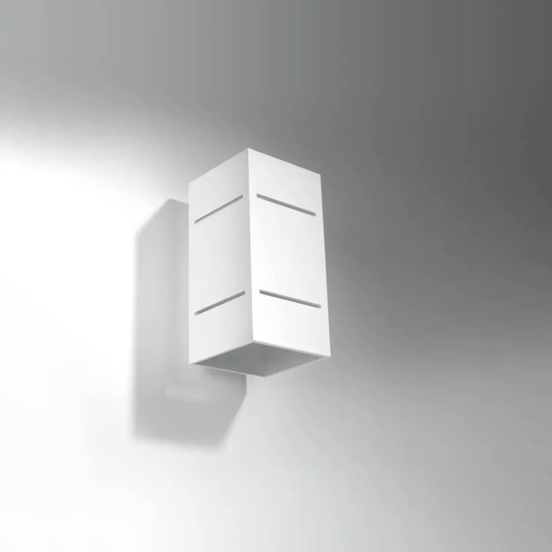 Applique murale blocco blanc avec design minimaliste et perforation linéaire pour un spectacle lumineux doux