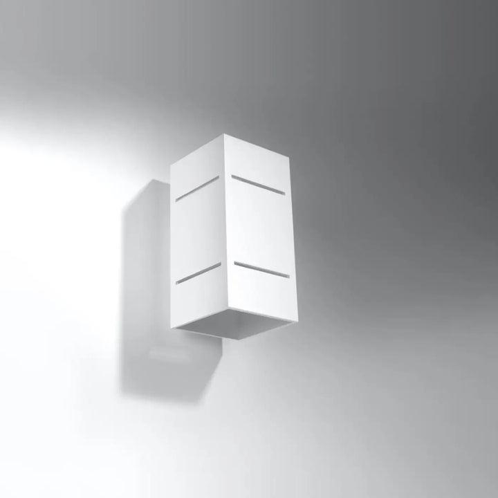 Applique murale blocco blanc avec design minimaliste et perforation linéaire pour un spectacle lumineux doux