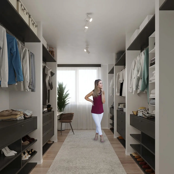 Une femme en top sans manches bordeaux et pantalon blanc dans un dressing moderne avec applique murale blanc lemmi 1 et module led pour une lumière conviviale