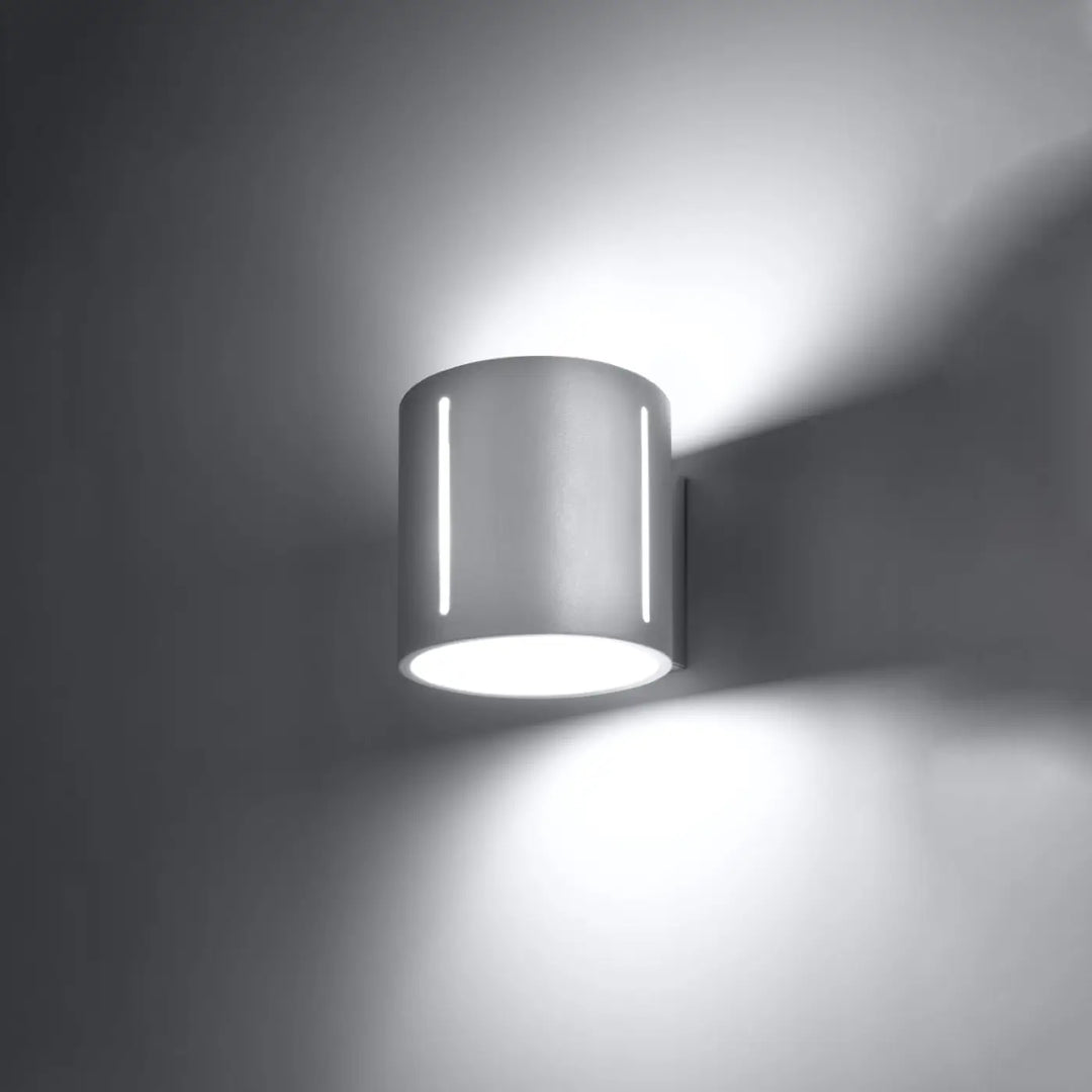 Applique murale inez blanche moderne en métal avec perforation linéaire et deux bandes led verticales émettant une lumière blanche brillante