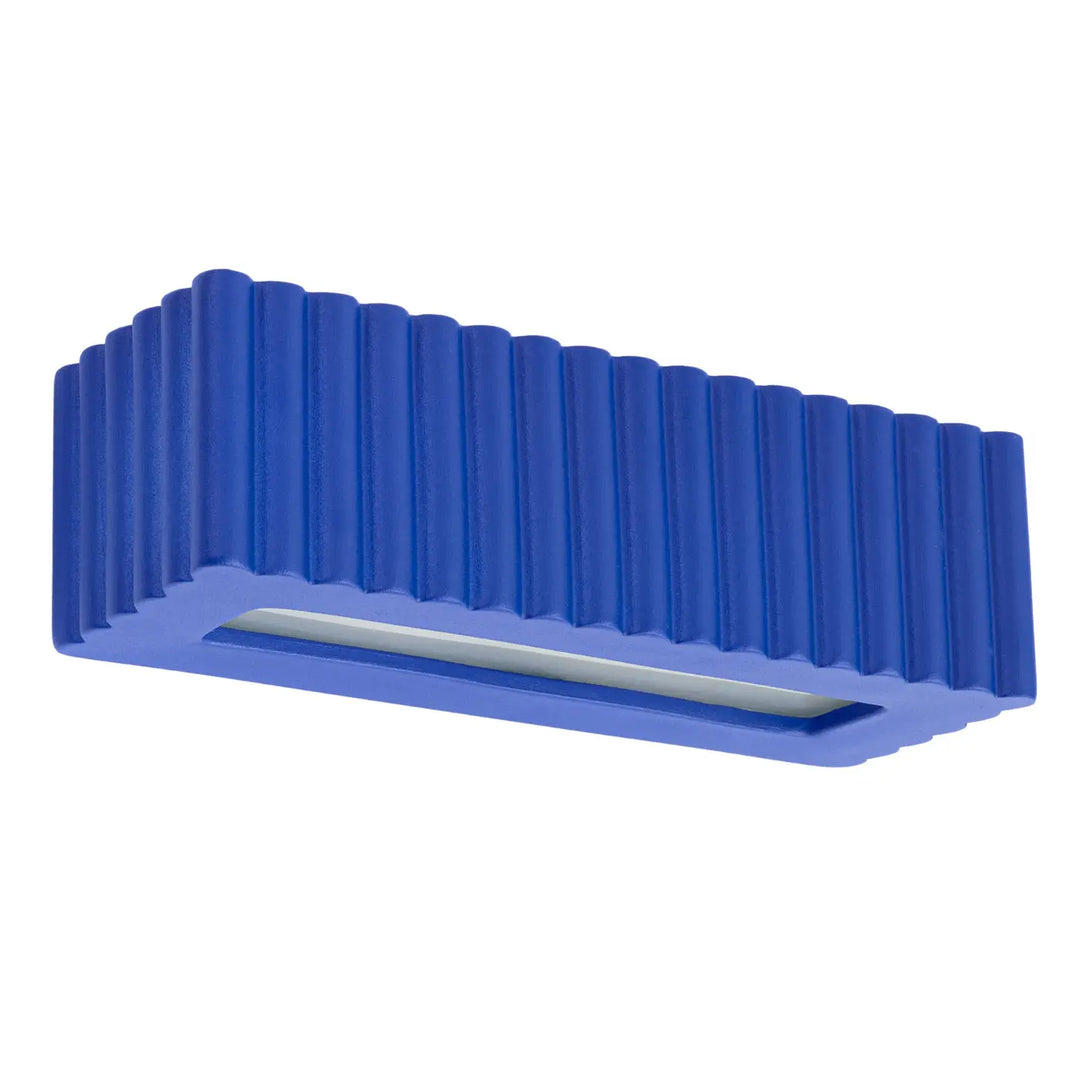 Clé usb bleue avec rainures verticales et fente centrale associée à l’applique murale rigata en céramique outremer