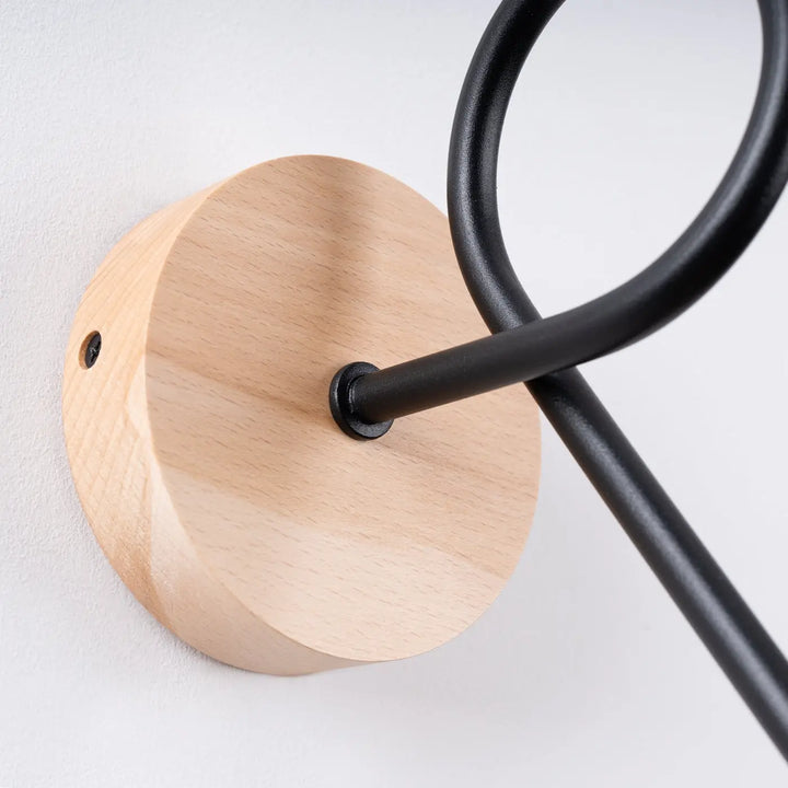 Applique murale lampe ember avec base circulaire en bois naturel et bras métalliques noirs design moderne