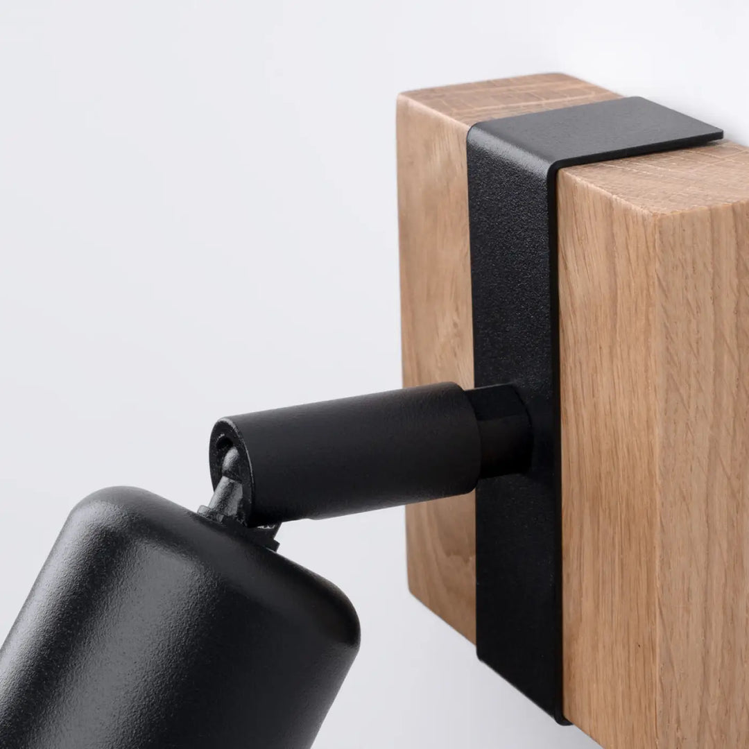 Applique murale ZUCA noir en métal mat avec tête cylindrique et ampoules décoratives visibles sur bloc en bois