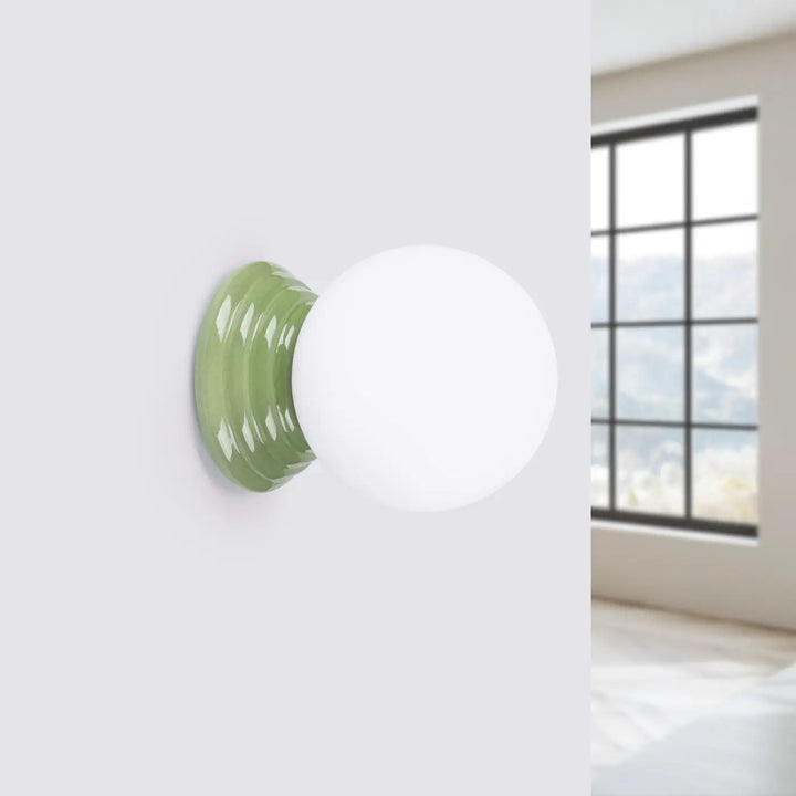 Applique murale lampe zori avec globe sphérique blanc mat et base en céramique vert sauge texturée pour belle décoration
