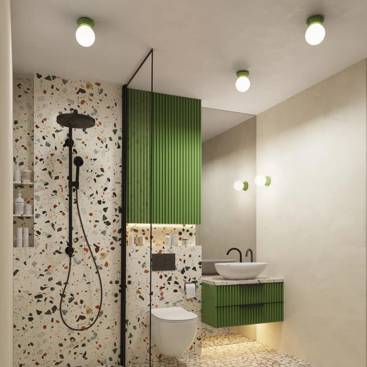 Applique murale lampe zori vert avec panneau vertical vert dans salle de bain moderne aux qualités esthétiques terrazzo