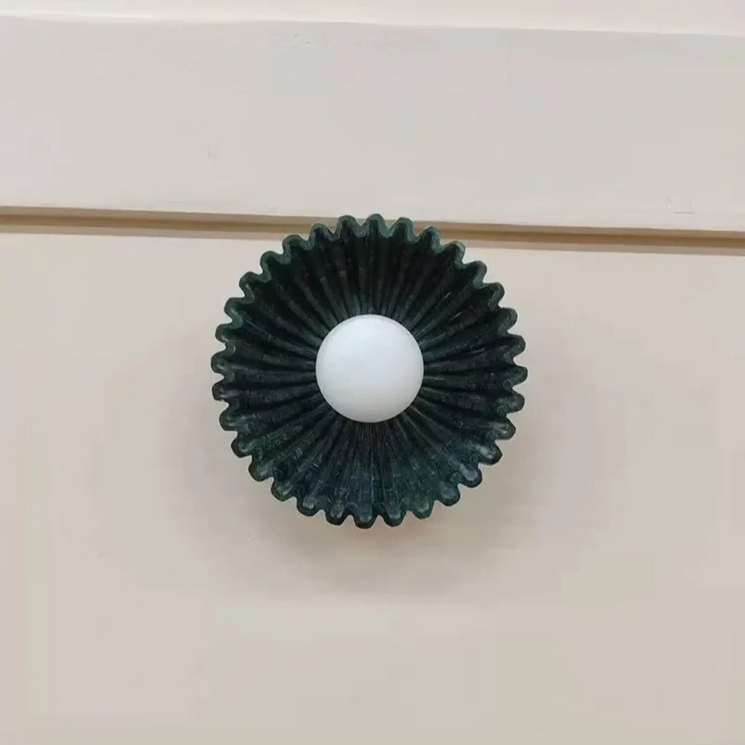 Applique murale akora avec globe lumineux central blanc et motif soleil vert foncé en forme de bouton de meuble