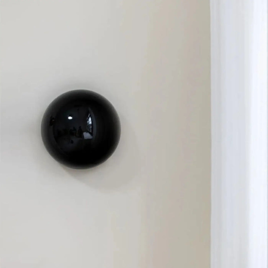 Applique murale orbys métal miroir noir sphérique à finition brillante pour une lumière douce élégante
