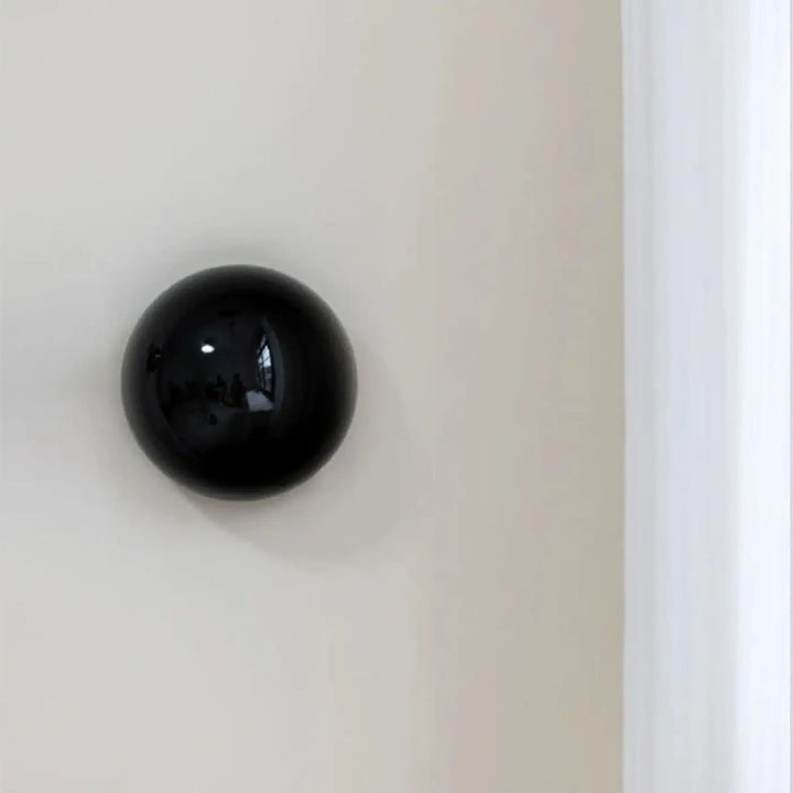 Applique murale orbys métal miroir noir sphérique à finition brillante pour une lumière douce élégante