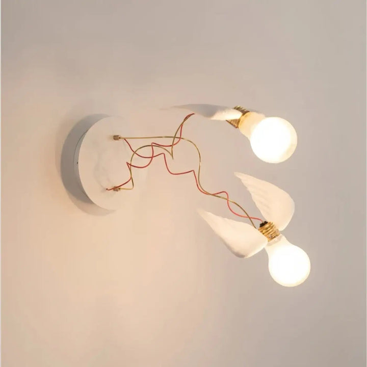 Applique murale contemporaine blanche avec deux ampoules lumineuses reliées par fils rouge et or design élégant ailes