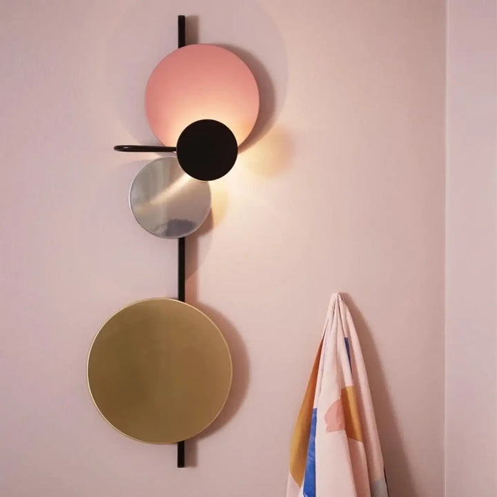 Applique murale pikso design aux formes géométriques avec abat-jours circulaires empilés en rose noir argenté et doré