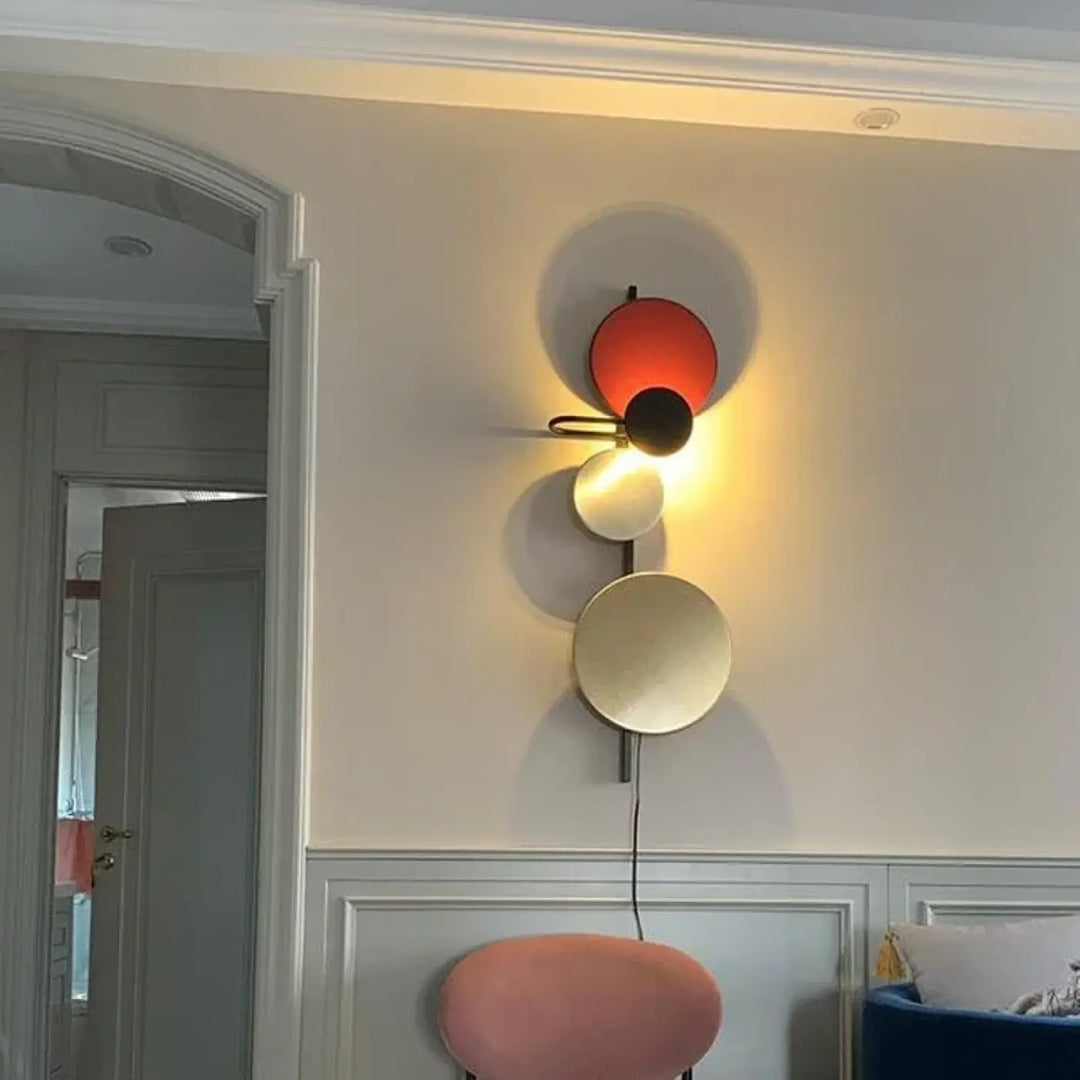 Applique murale pikso avec formes géométriques en nuances rouge vif, noir mat et or métallique au design minimaliste