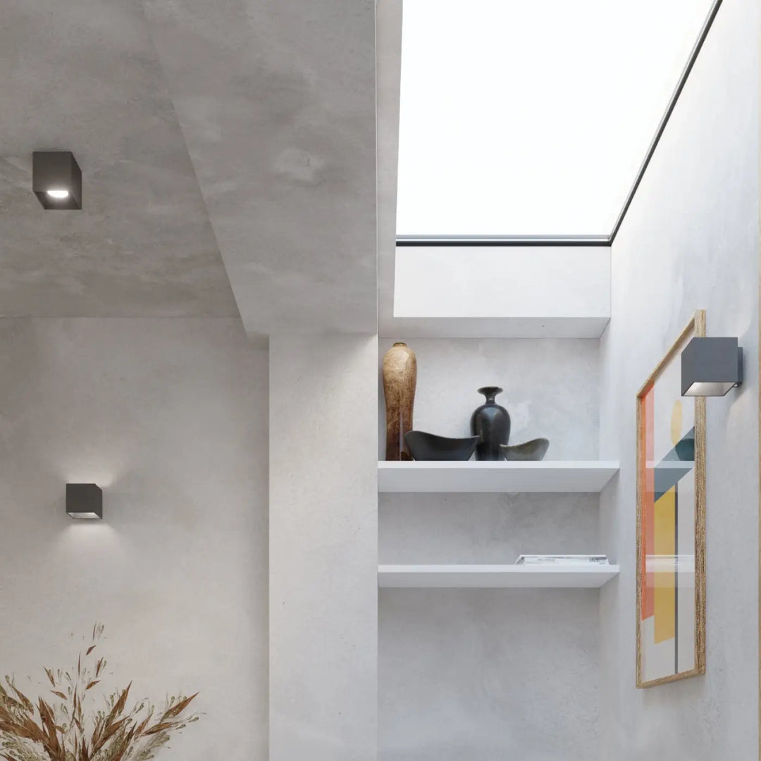 Applique murale quad 1 anthracite avec vase en céramique noire au col fin sur étagère en bois naturel blanc