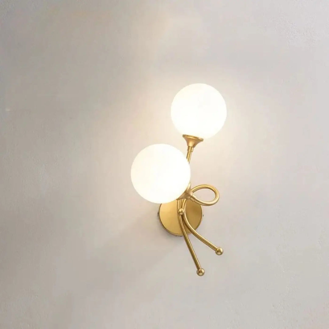 Applique murale zylo en métal doré avec deux globes en verre dépoli et un design en forme de nœud décoratif