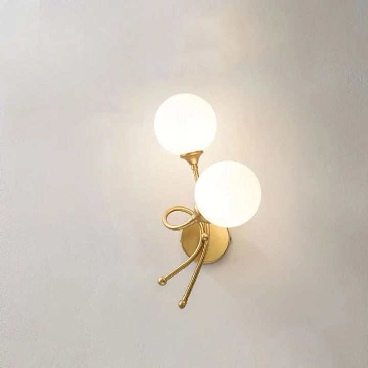 Applique murale zylo en métal doré avec deux globes en verre dépoli et base décorative en forme de nœud
