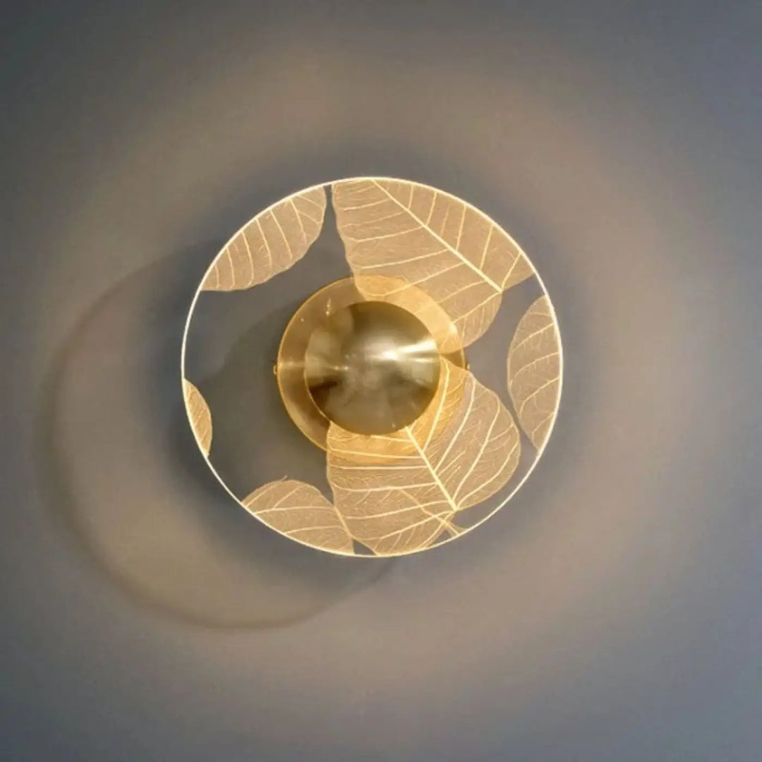 Applique murale thessa circulaire dorée avec motif feuilles et fixation centrale en laiton pour décoration murale
