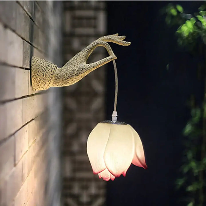 Applique murale artus en forme de main dorée avec design floral tenant une lumière douce en forme de lotus