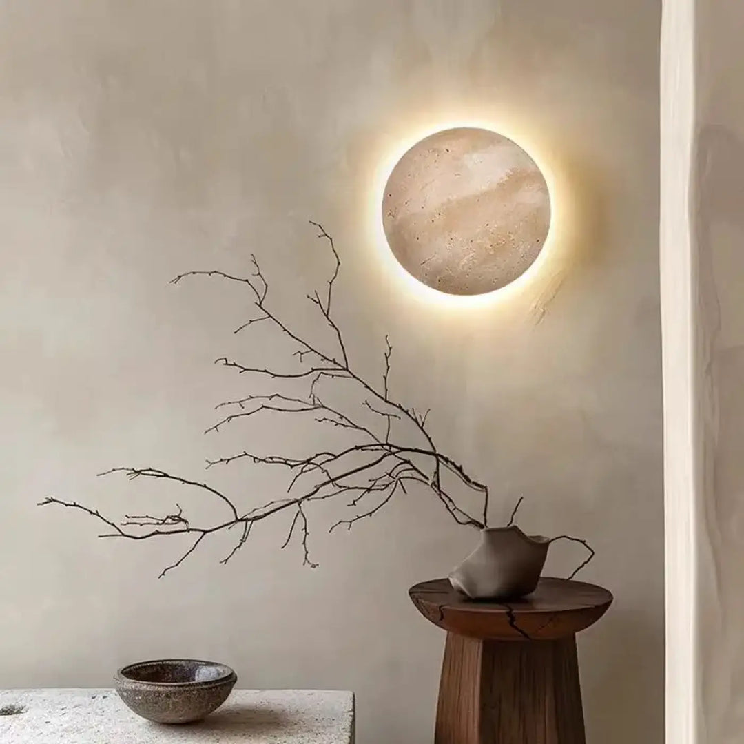 Applique murale circulaire pierre texturée tons terre avec lumière ambiante chaude PIERLUNE