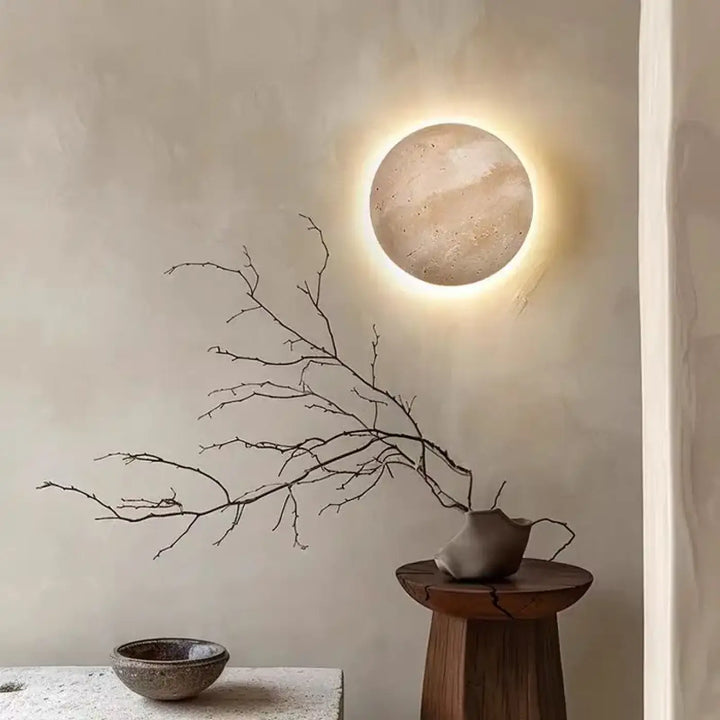 Applique murale circulaire pierre texturée tons terre avec lumière ambiante chaude PIERLUNE