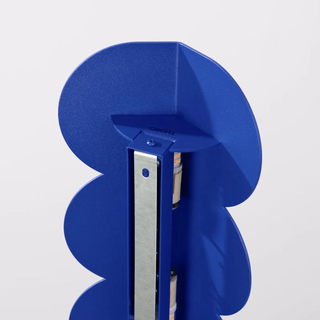 Applique murale biscuit outremer compose d’une lampe bleu metallique avec forme ondulée caractéristique et bande led visible