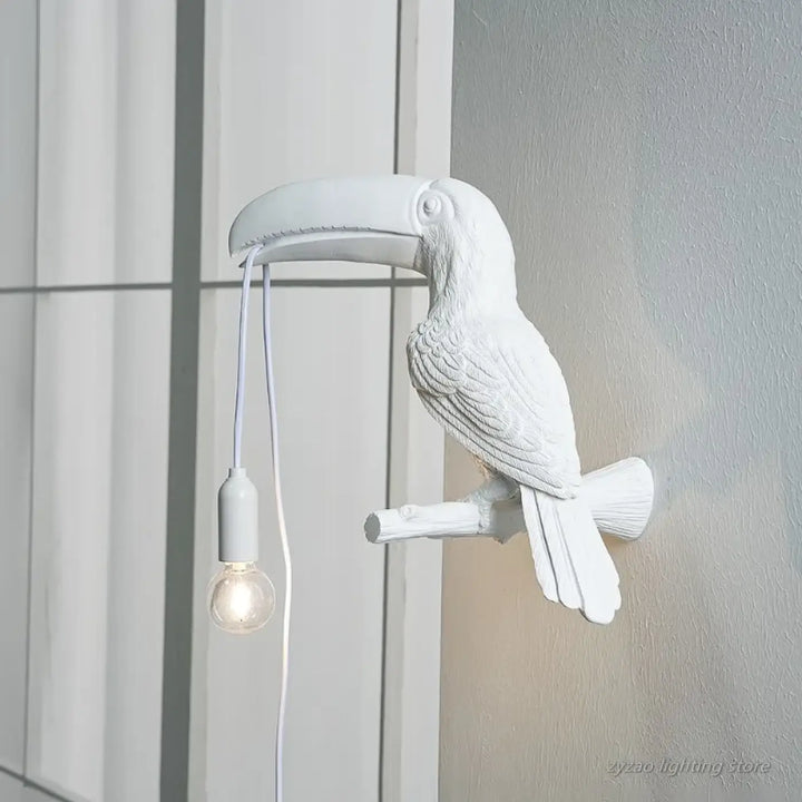 Applique murale blanche en forme de toucan avec plumes texturées et ampoule suspendue design toucan perché
