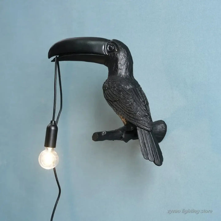 Applique murale design toucan noir avec finition matte texturée et ampoule apparente suspendue à son bec