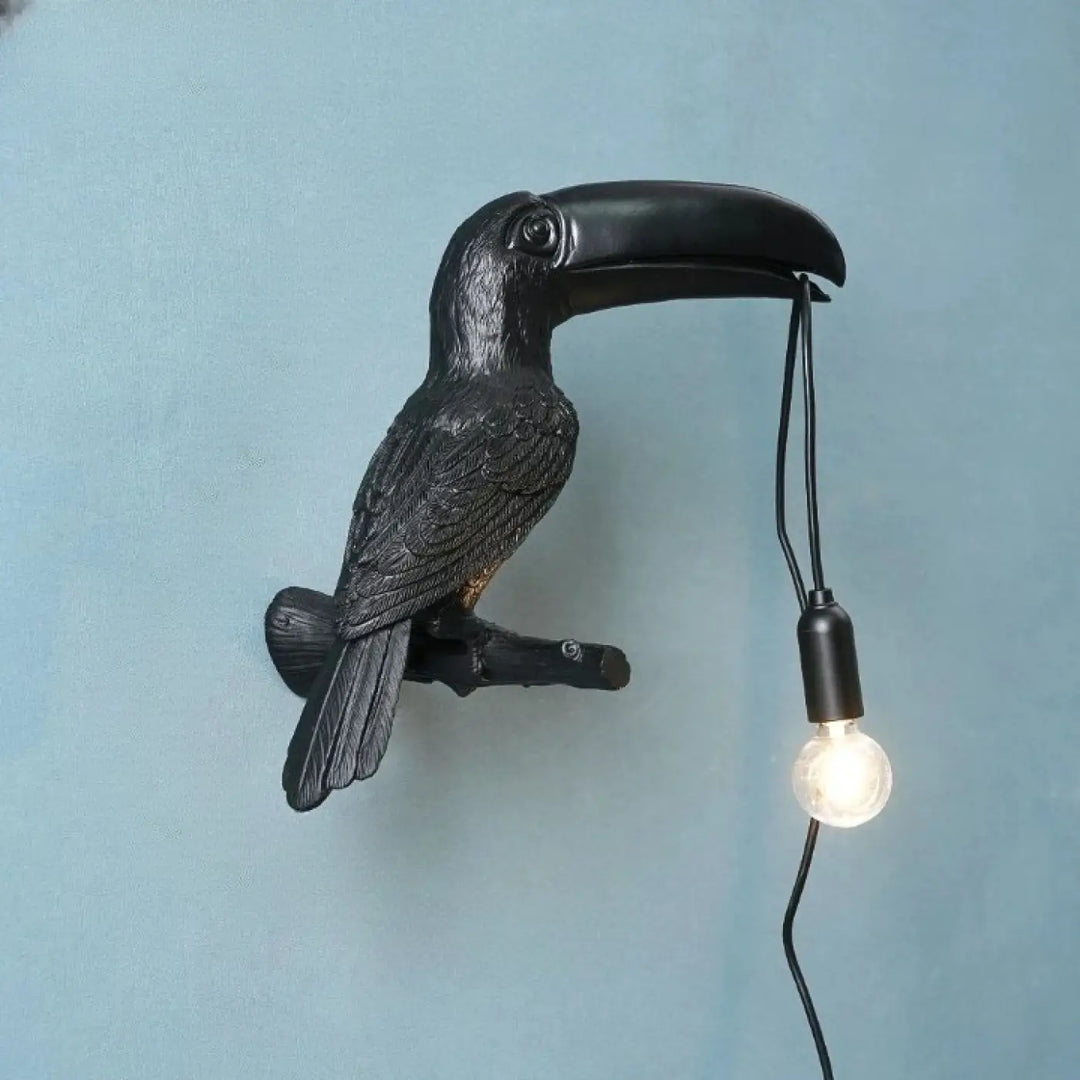 Applique murale design toucan noir avec finition mate texturée et ampoule apparente suspendue au bec design toucan perché