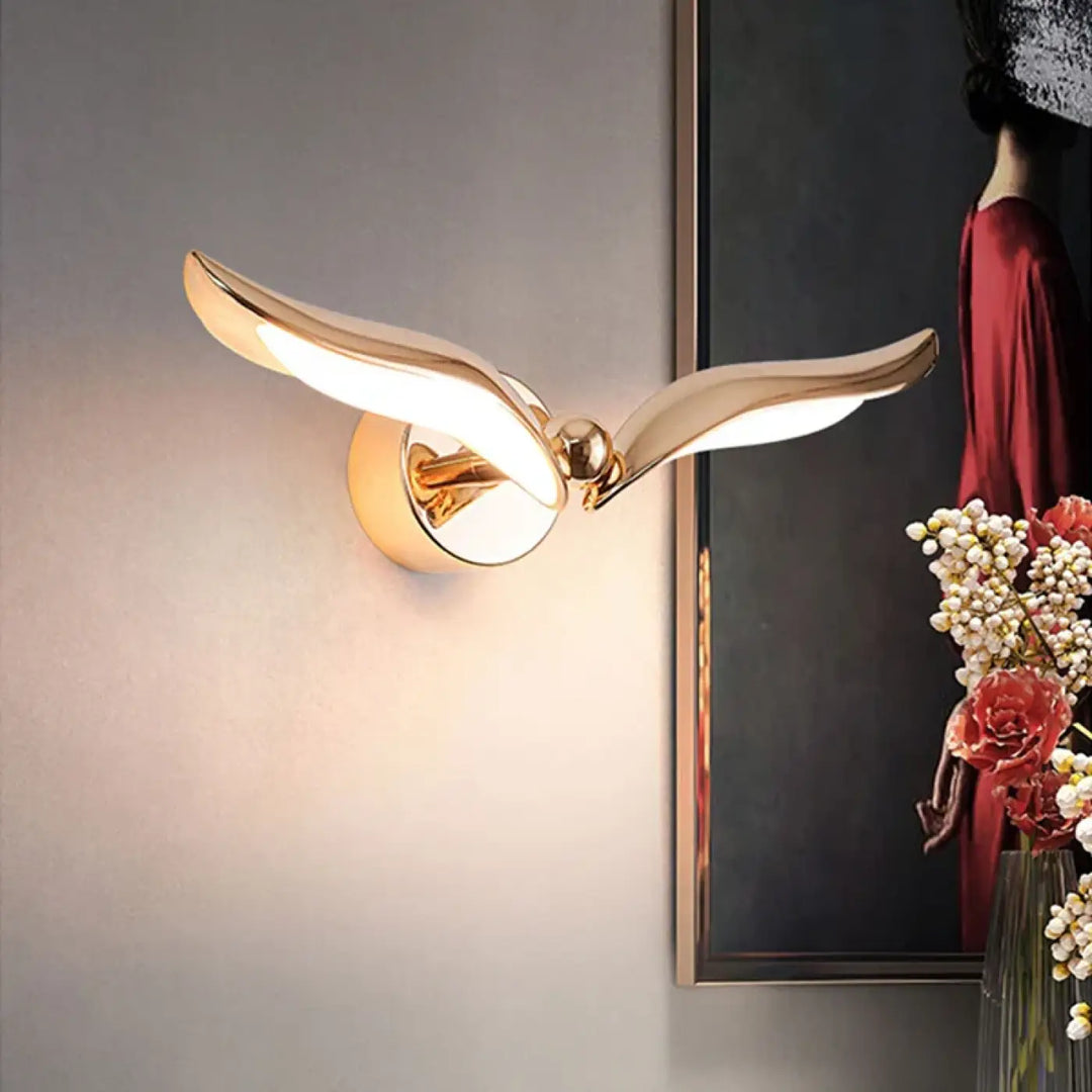 Applique Murale Doré Avec Un Design Similaire À Une Oiseau

