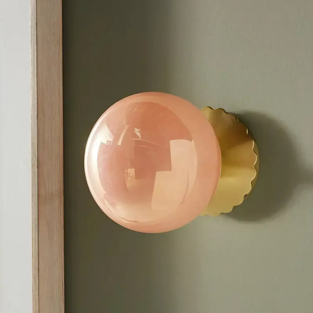 Applique murale élégant en verre rose et base dorée moderne