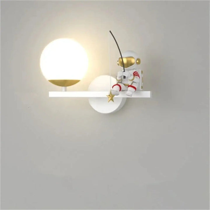 Applique murale alora avec figurine astronaute blanche et or aux accents rouges posée sur un luminaire mural minimaliste