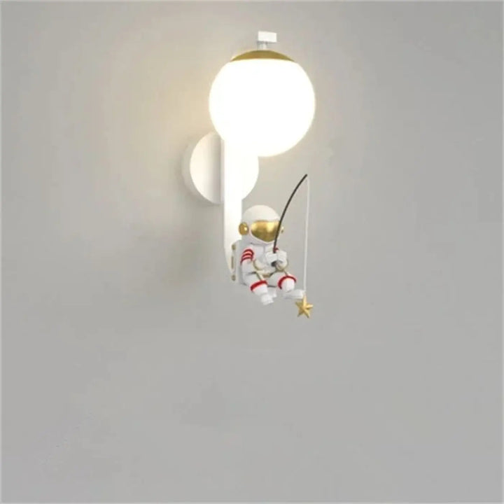 Applique murale enfantine blanche avec accents dorés et rayures rouges tenant une canne à pêche attrapant une étoile dorée