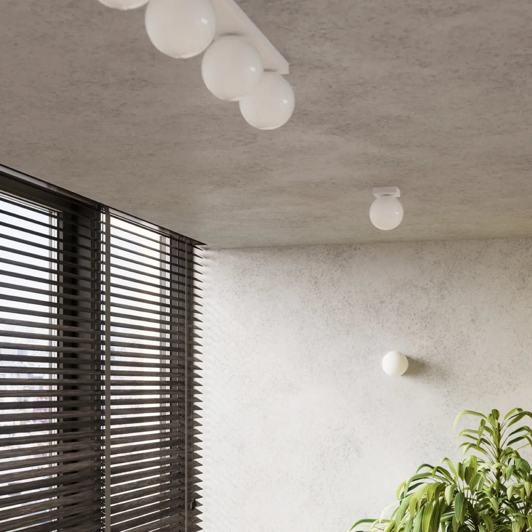 Applique yoli 1 avec boîtier sphérique blanc d’une élégance minimaliste montée au plafond et au mur