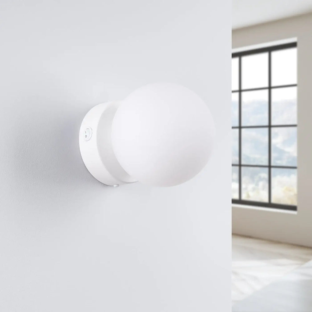 L’applique yoli avec boîtier sphérique blanc en verre dépoli et base métal d’une élégance minimaliste