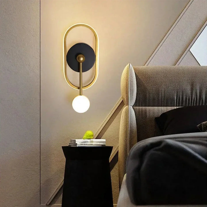Applique murale haloria avec cadre doré moderne, accent noir circulaire et ampoule sphérique blanche lumineuse design murale