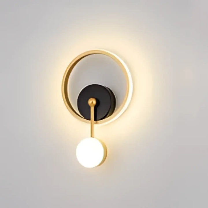 Applique murale haloria en métal doré avec disque noir central et ampoule sphérique blanche suspendue design murale