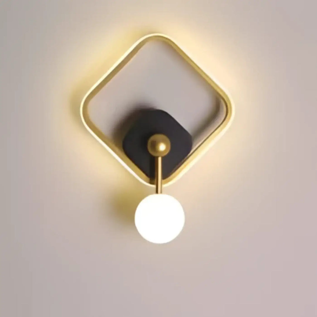 Applique murale haloria en métal doré avec centre circulaire noir et ampoule sphérique blanche design géométrique