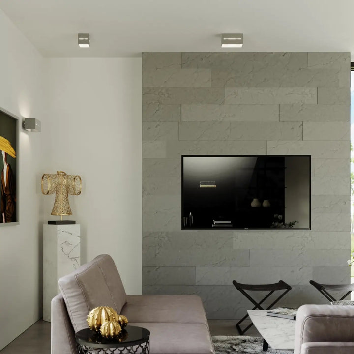 Un téléviseur écran plat noir élégant monté sur une applique murale lobo gris en marbre avec perforation linéaire moderne