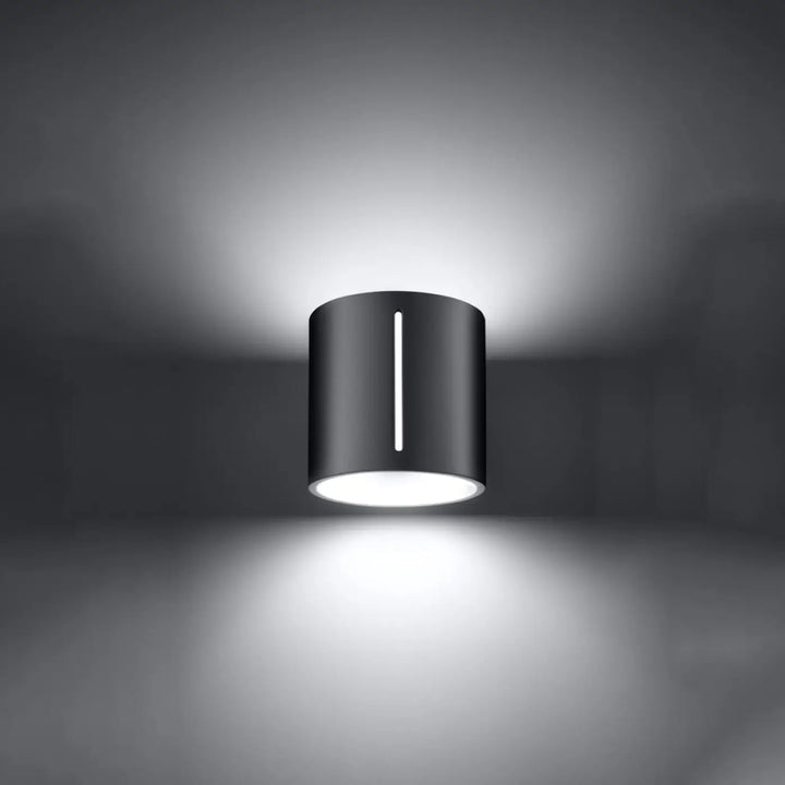 Applique murale moderne inez gris en cylindre noir avec perforation linéaire et illumination blanche diffusée