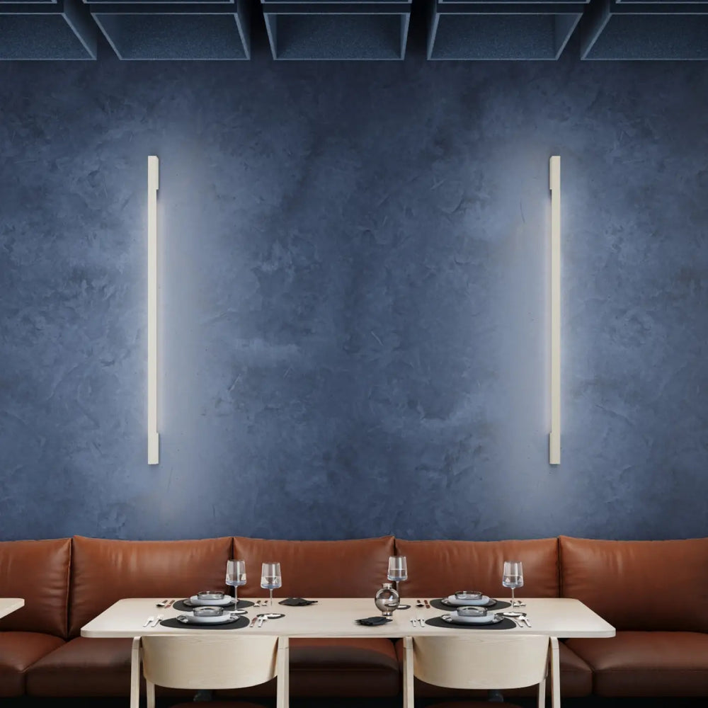 Deux applique murale lahti 70 beige avec module led intégré et boîtier allongé émettant une lumière blanche douce sur mur vert olive