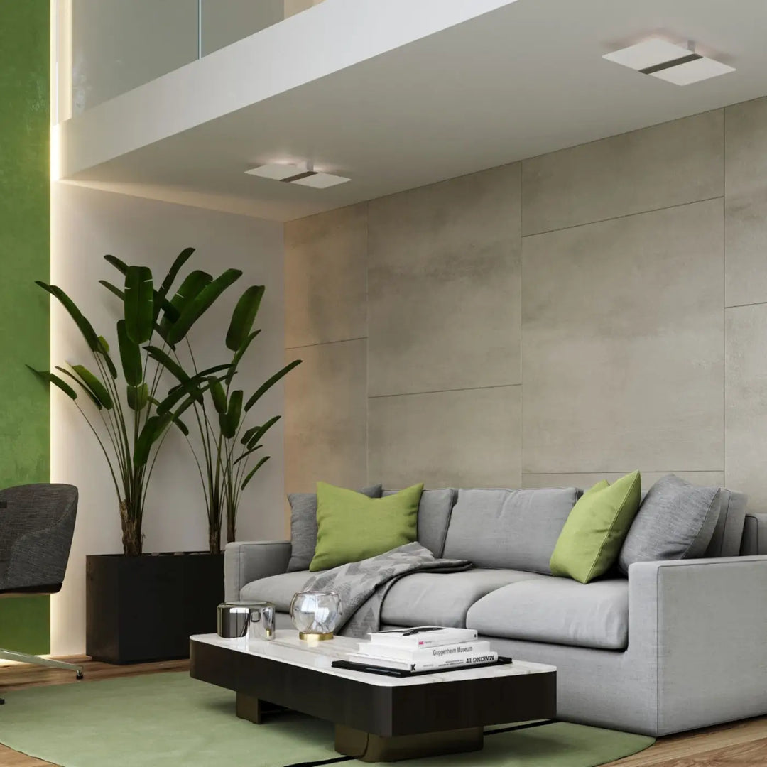 Applique murale azalia avec canapé sectional gris, coussins verts et plaid gris, design intemporel blanc met magnifiquement