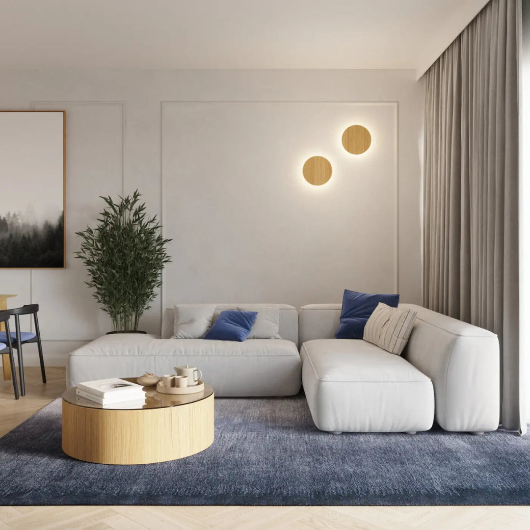 Applique murale borgen 3000k en bois près d un canapé modulable blanc moderne avec coussins moelleux et oreillers bleus