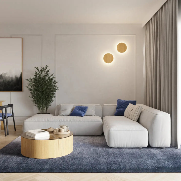 Applique murale borgen 3000k en bois près d un canapé modulable blanc moderne avec coussins moelleux et oreillers bleus