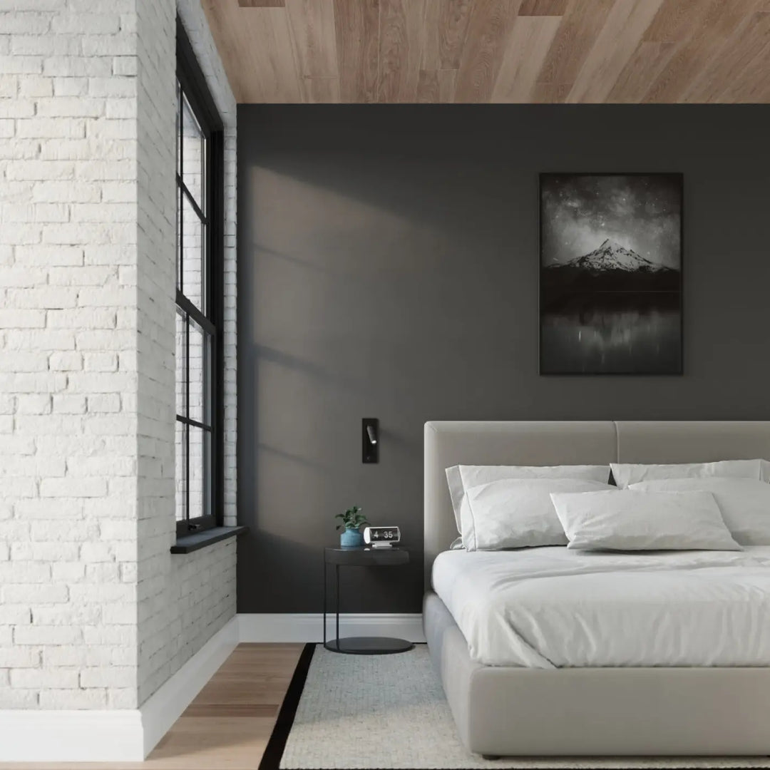 Applique murale minimaliste série enif noir installée au-dessus d un lit moderne gris avec literie blanche et coussins multiples